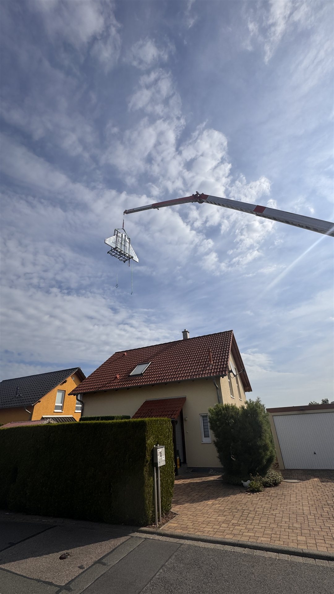 Dreieckiges Giebelelement wird per Autokran &uuml;ber das Dach gehoben