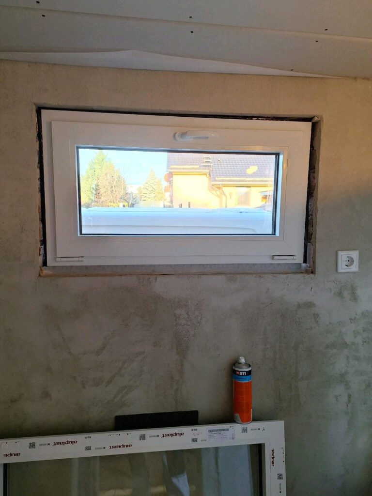 Neu eingesetztes Fenster im Bestand, die Anschlussfuge ist noch offen und das umlaufende Dichtband sichtbar.
