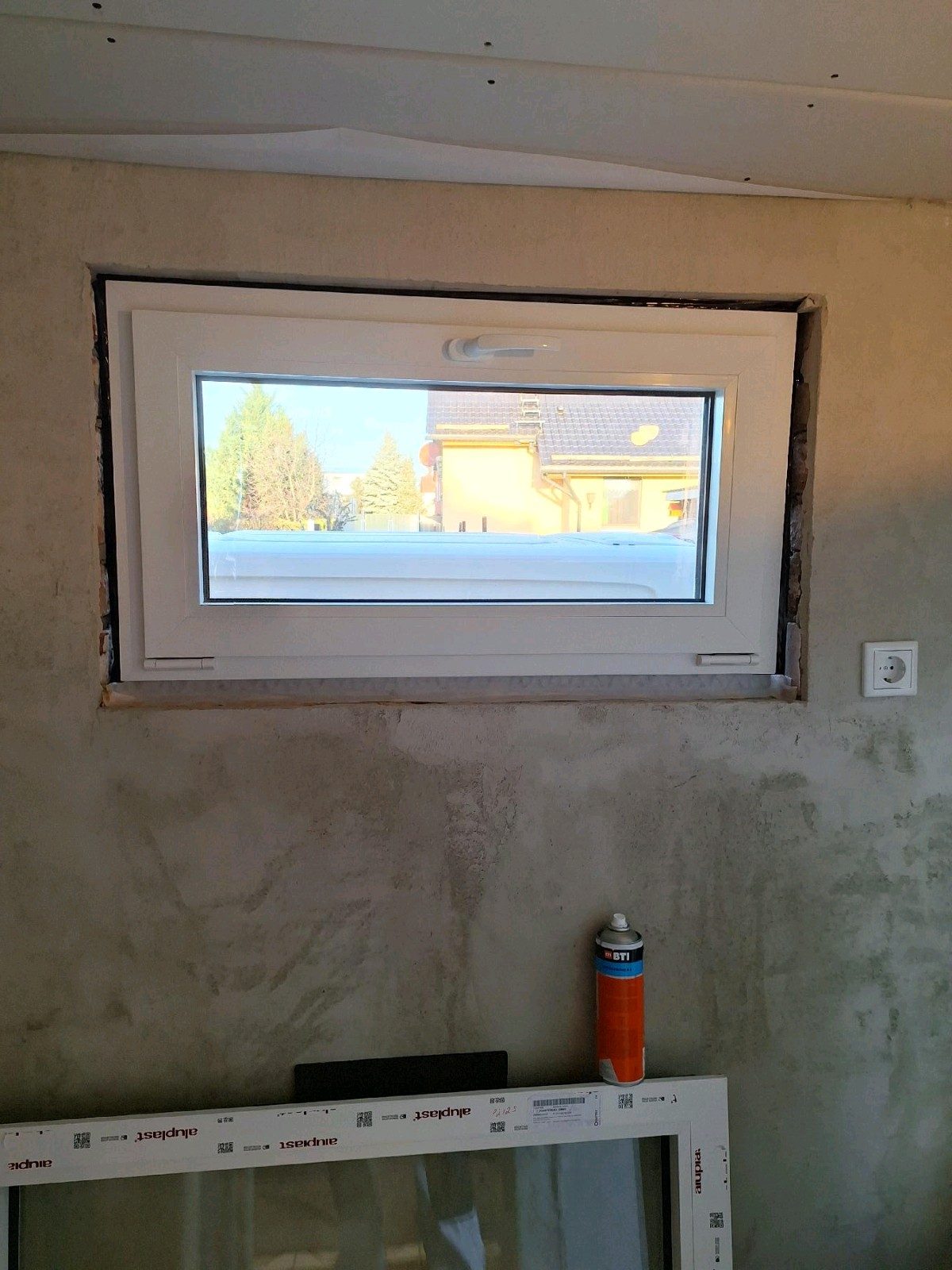Neu eingesetztes Fenster im Bestand, die Anschlussfuge ist noch offen und das umlaufende Dichtband sichtbar.